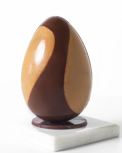 Front view egg two-colored brown and dark choco on the white floor
