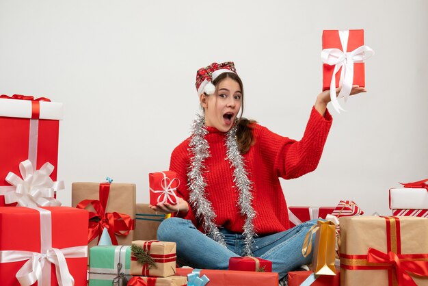 산타 모자 선물 주위에 앉아 선물을 들고 전면보기 의기 양양 소녀