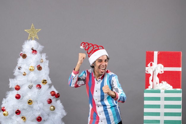 Front view elated young man with spiral spring santa hat showing his happiness