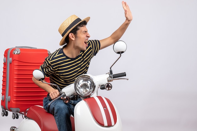 Free photo front view elated young man with straw hat on moped hailing somene