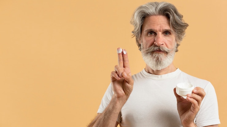Free Photo front view of elder bearded man with moisturizer and copy space