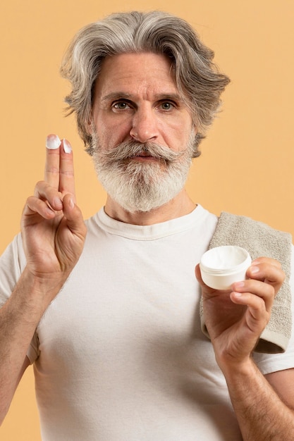 Foto gratuita vista frontale dell'uomo anziano barbuto con crema idratante
