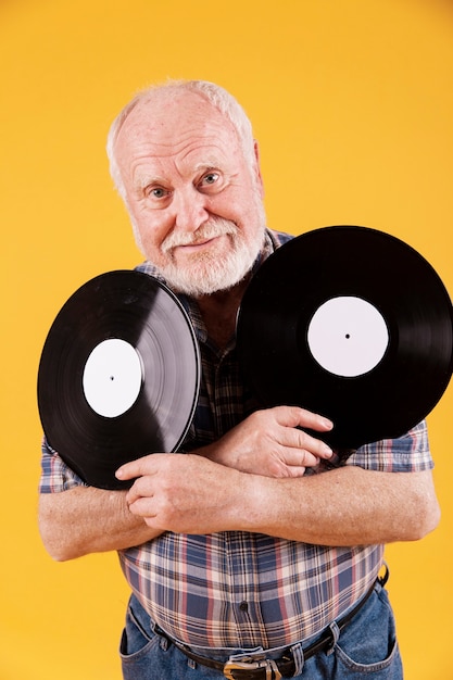 Vista frontale uomo anziano con dischi musicali