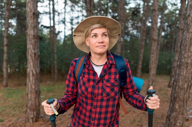 Front view of elder tourist woman in the forest