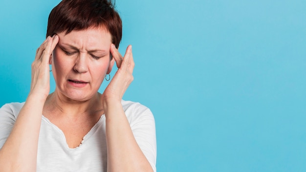 Front view of elder woman experiencing headache