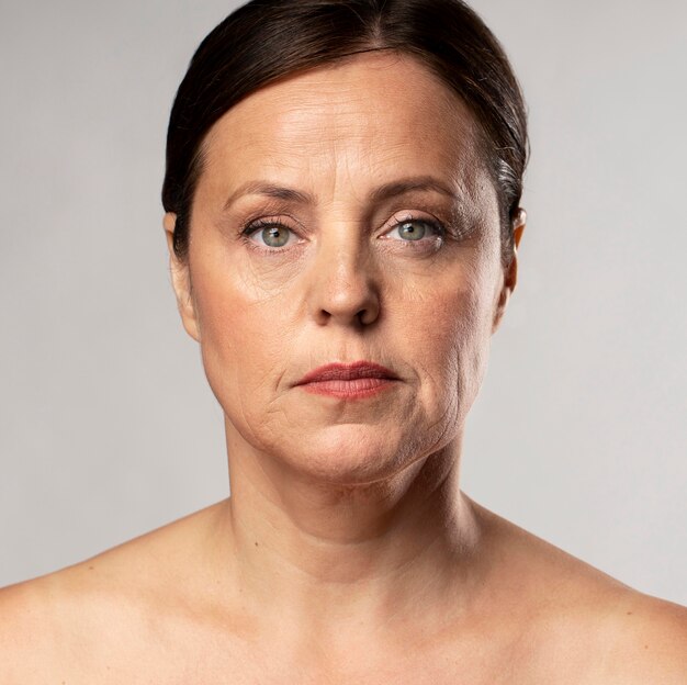 Front view of elder woman posing stoic with make-up on