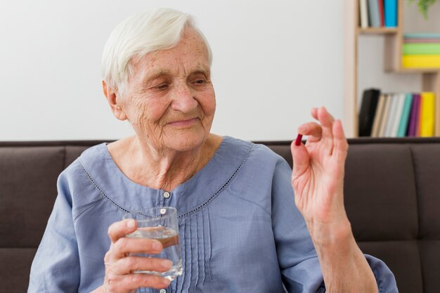 Front view of elder woman taking her daily pill