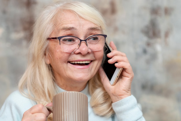Вид спереди старшая женщина разговаривает по телефону