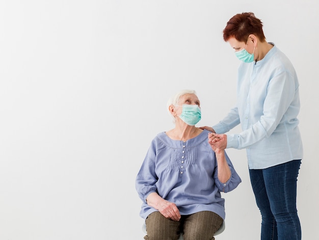 Front view of elder women with medical masks and copy space