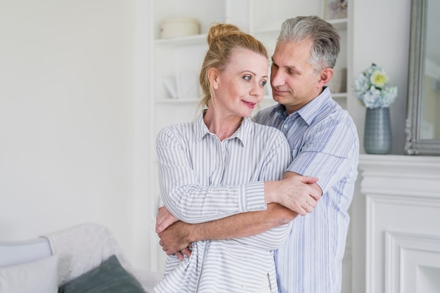 Front view elderly man holding woman