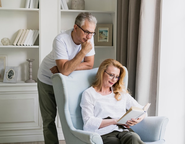 Front view elderly man and woman reading a book