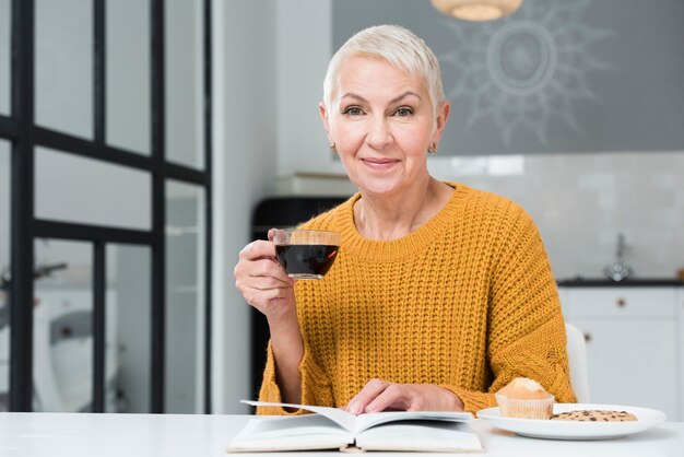 コーヒーカップを保持している高齢者の女性の正面図