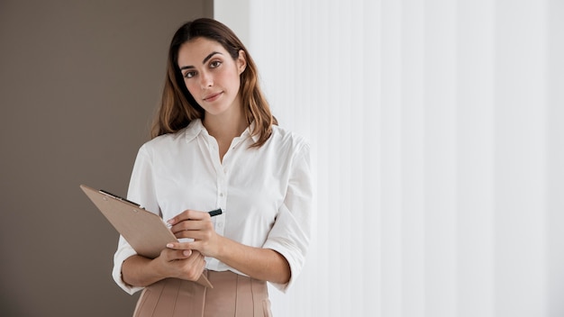 Front view of elegant businesswoman holding clipboard