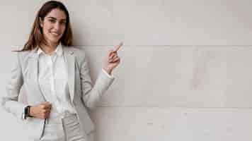 Free photo front view of elegant businesswoman pointing to the right
