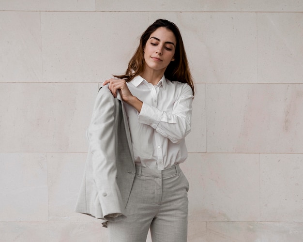 Free photo front view of elegant businesswoman putting on a suit