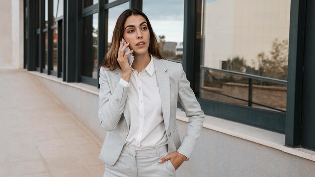 Front view of elegant businesswoman talking on the phone in the city