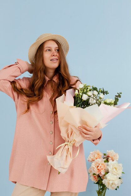 Free photo front view of elegant woman posing with bouquet of spring flowers