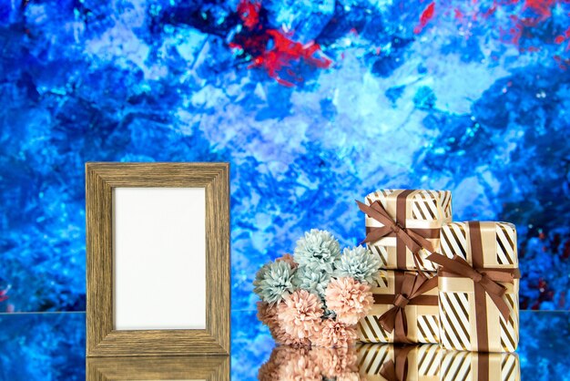 Front view empty photo frame valentines day presents flowers on blue abstract background