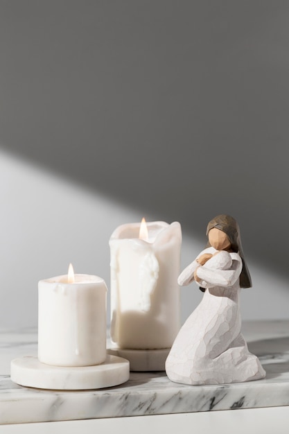 Вид спереди женской фигурки в день крещения со свечами