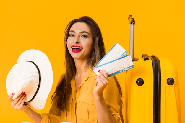 Front view of excited woman holding plane tickets