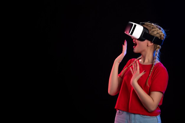 Front view of excited young female playing vr on black