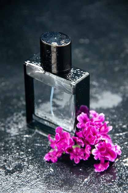 Vista frontale fragranza costosa con fiori sullo sfondo scuro colore profumo regalo presente amore matrimonio profumo fiore
