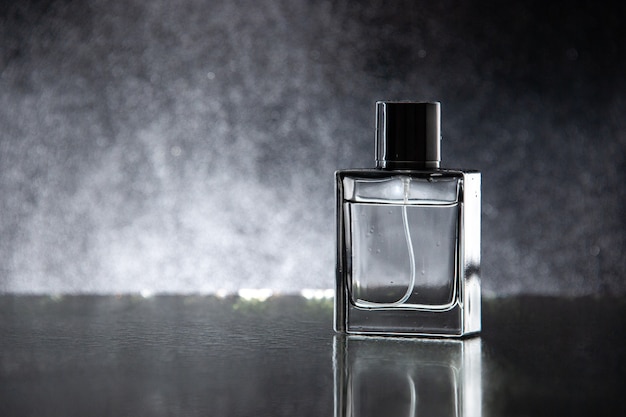 Front view expensive perfume as a present on the dark table