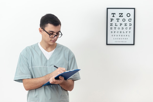 Front view of eye specialist holding notepad and writing