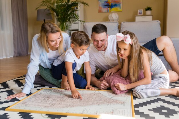 Front view family indoors looking at a blue print