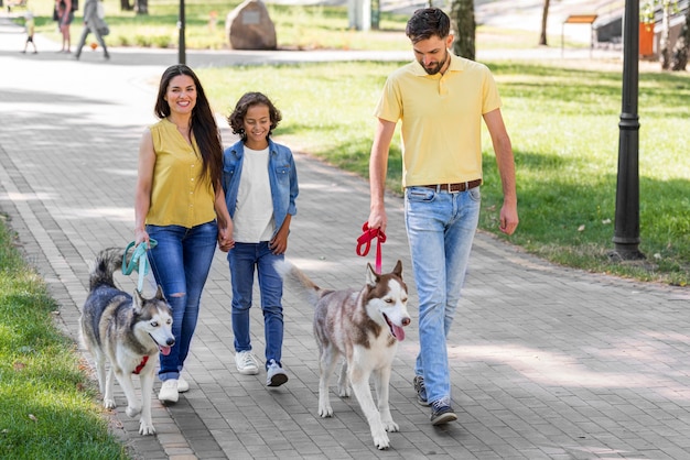 Front view of family with boy and dog at the park together