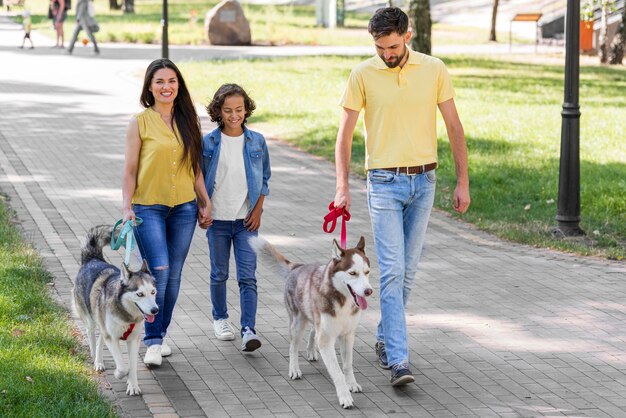 Front view of family with boy and dog at the park together