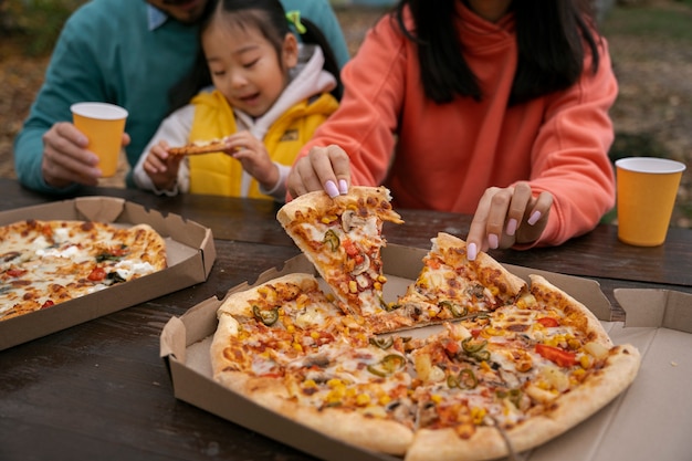 야외에서 맛있는 피자를 곁들인 정면 가족