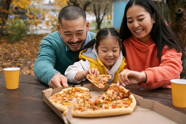 Famiglia vista frontale con deliziosa pizza fuori