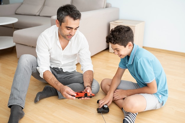 Free photo front view father and child playing with an electric car