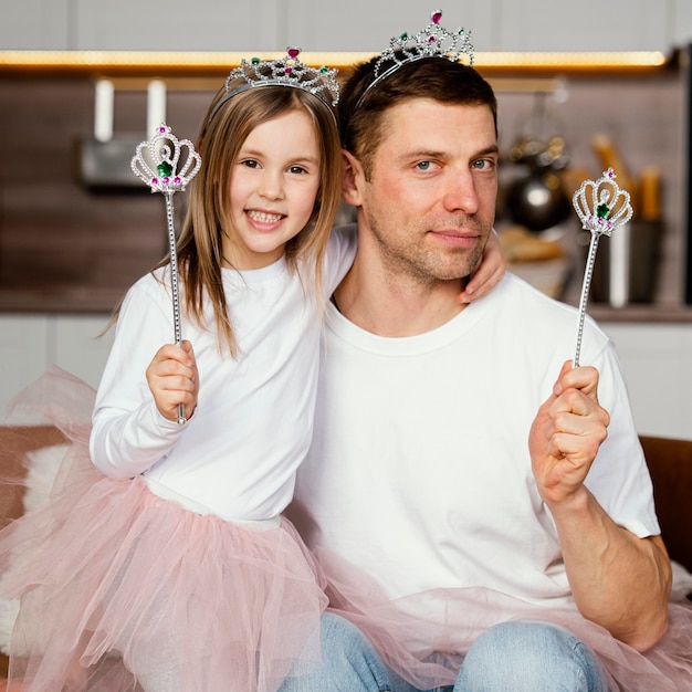 Free photo front view of father and daughter playing with tiara and wand