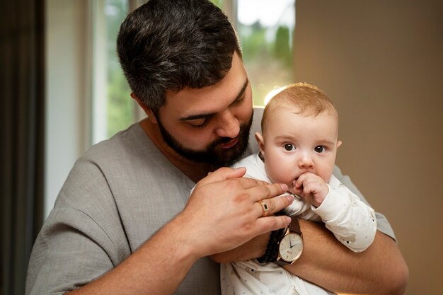 Front view father holding baby