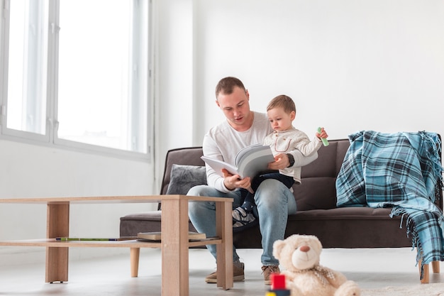 Front view of father holding son and reading