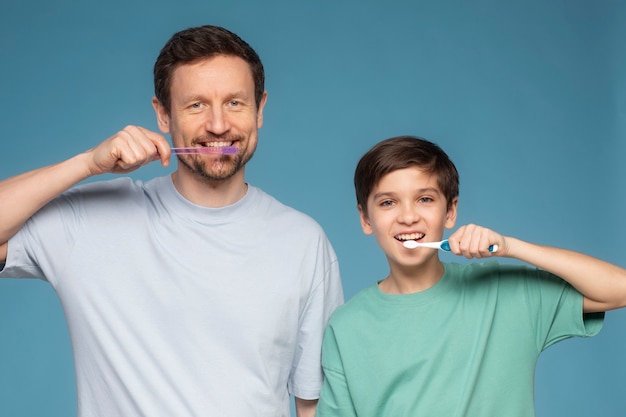 Front view father and kid brushing teeth