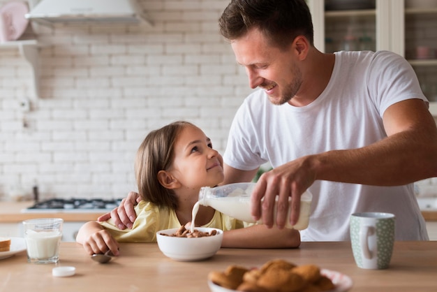 Front view father pouring milk in bowl