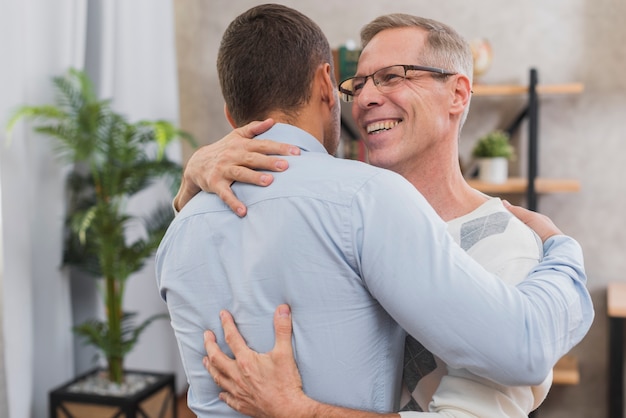 Free photo front view of father and son hugging