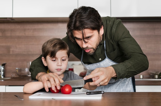 Free photo front view father and son in kitchen