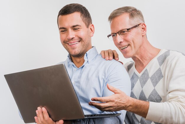 Front view of father and son looking at laptop