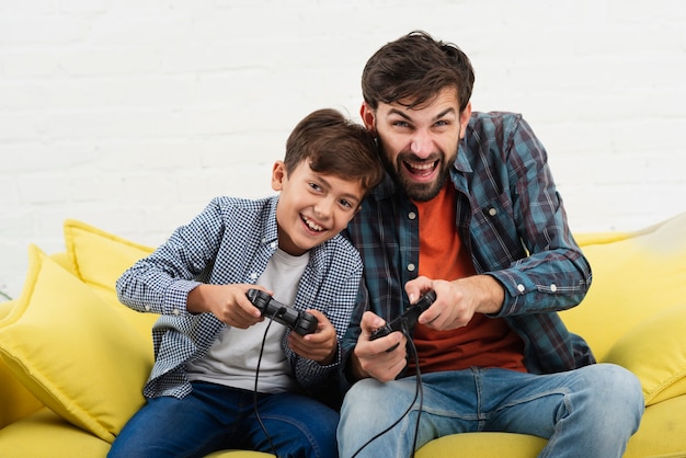 Front view father and son playing on console