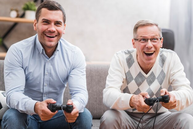 Front view of father and son playing with joystick