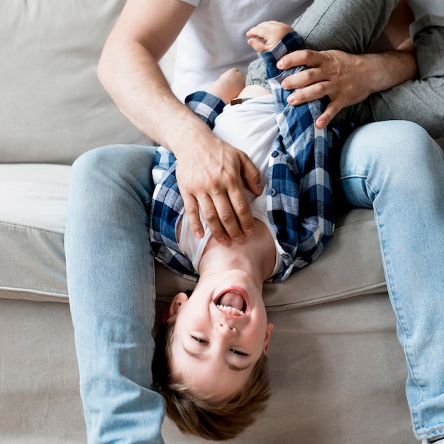 Free photo front view father tickling happy child