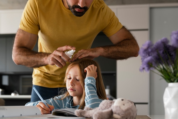 Foto gratuita padre di vista frontale che usa il trattamento dei pidocchi