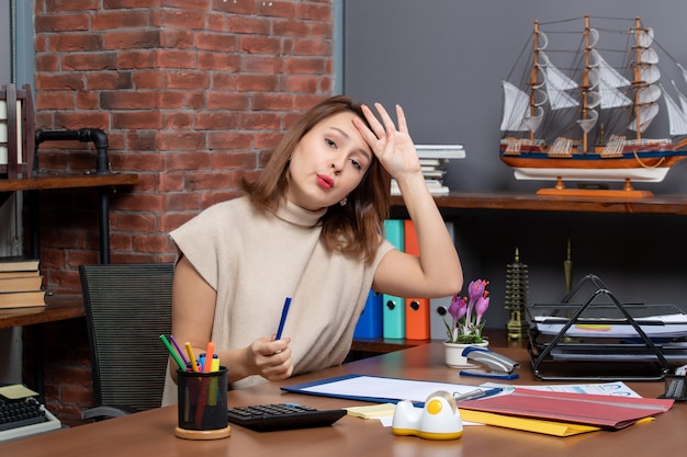 Front view fatigued business woman sitting at desk