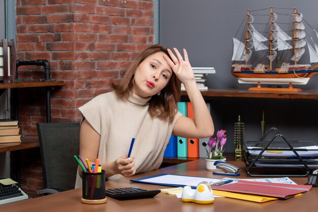 Front view fatigued business woman sitting at desk