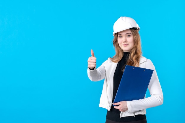 青の青いファイル計画を保持しているヘルメットの正面図の女性建築家