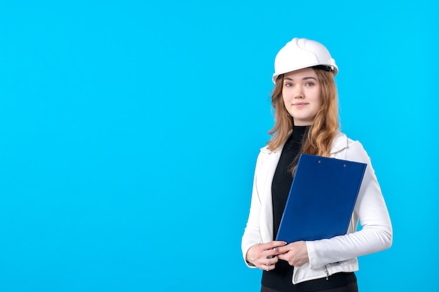 Front view female architect holding blue file plan on blue